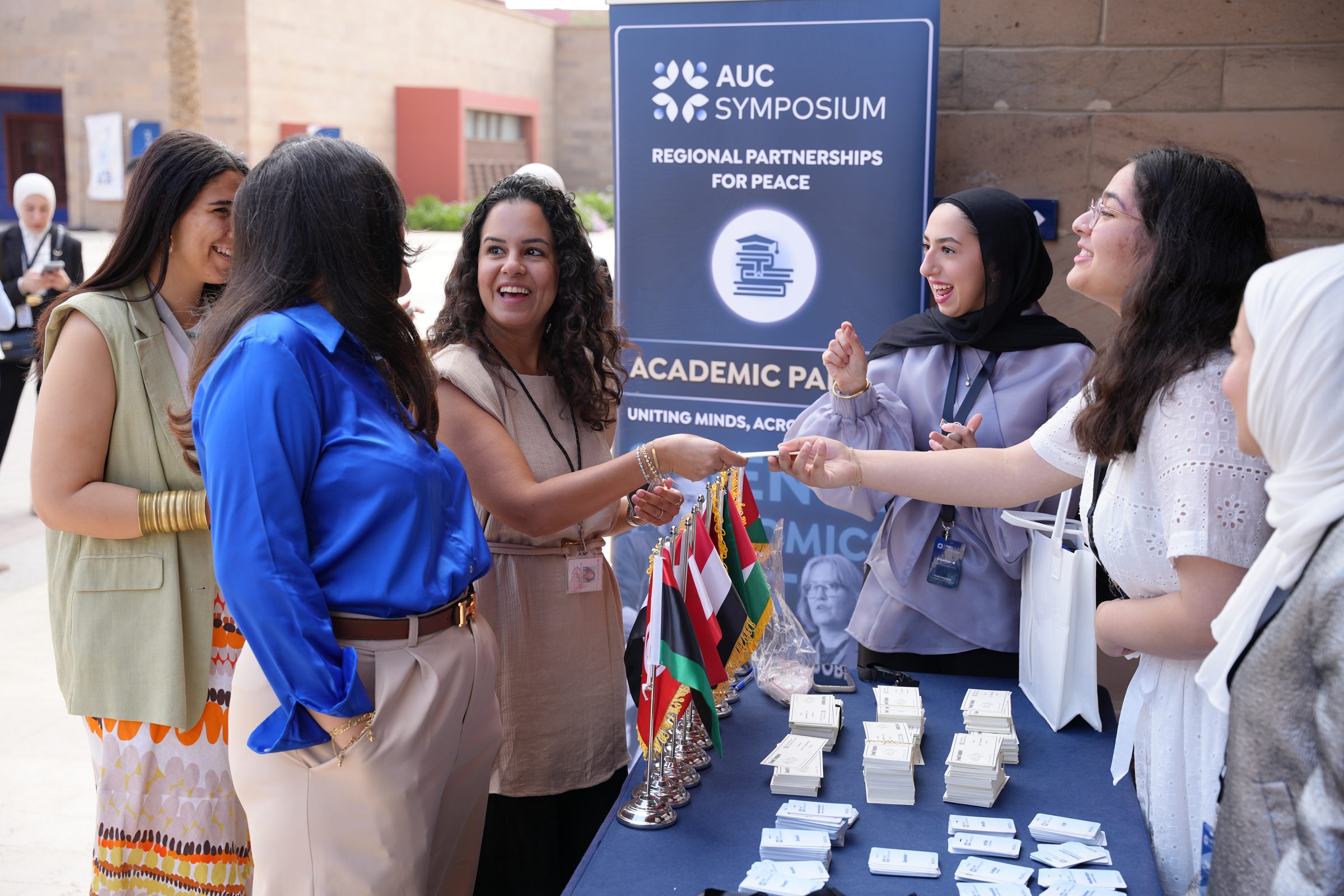 The welcome desk of the academic panels with the flags of the region