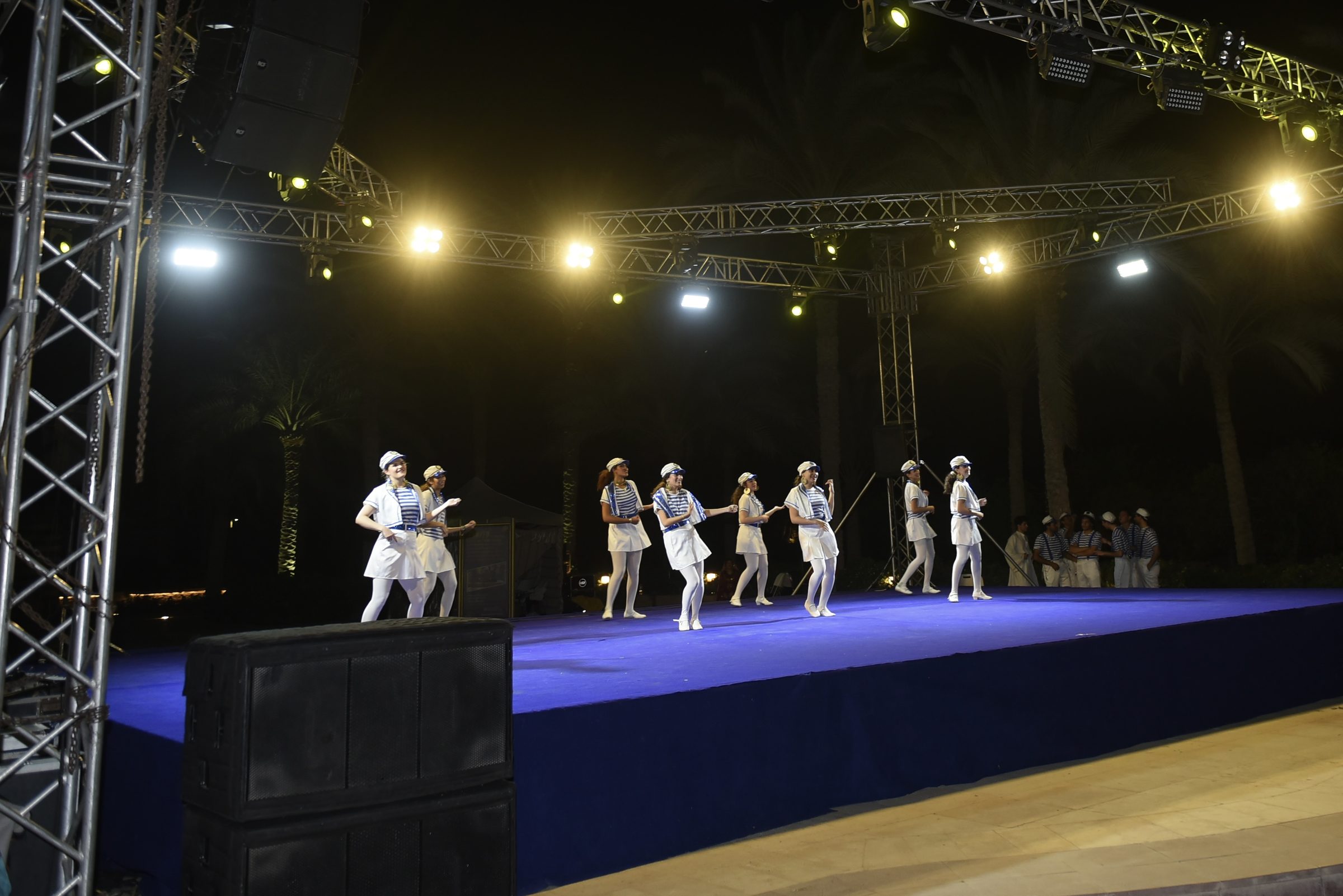 A folklore troupe dancing on the open-air stage at night