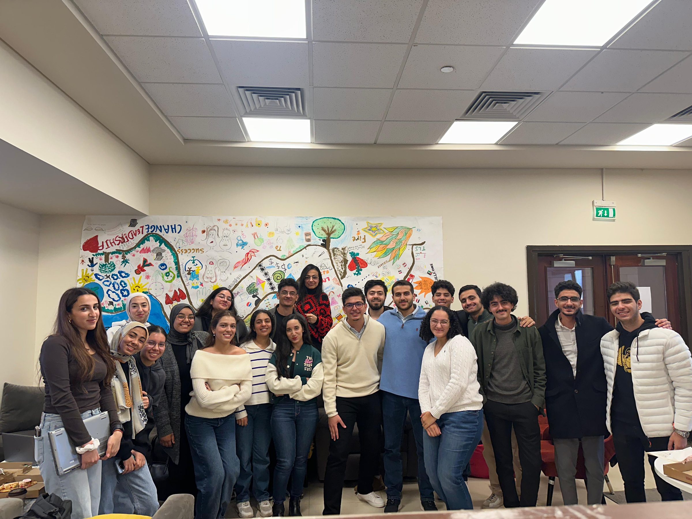 A cohort in front of a mural reading Change, Leadership, Success