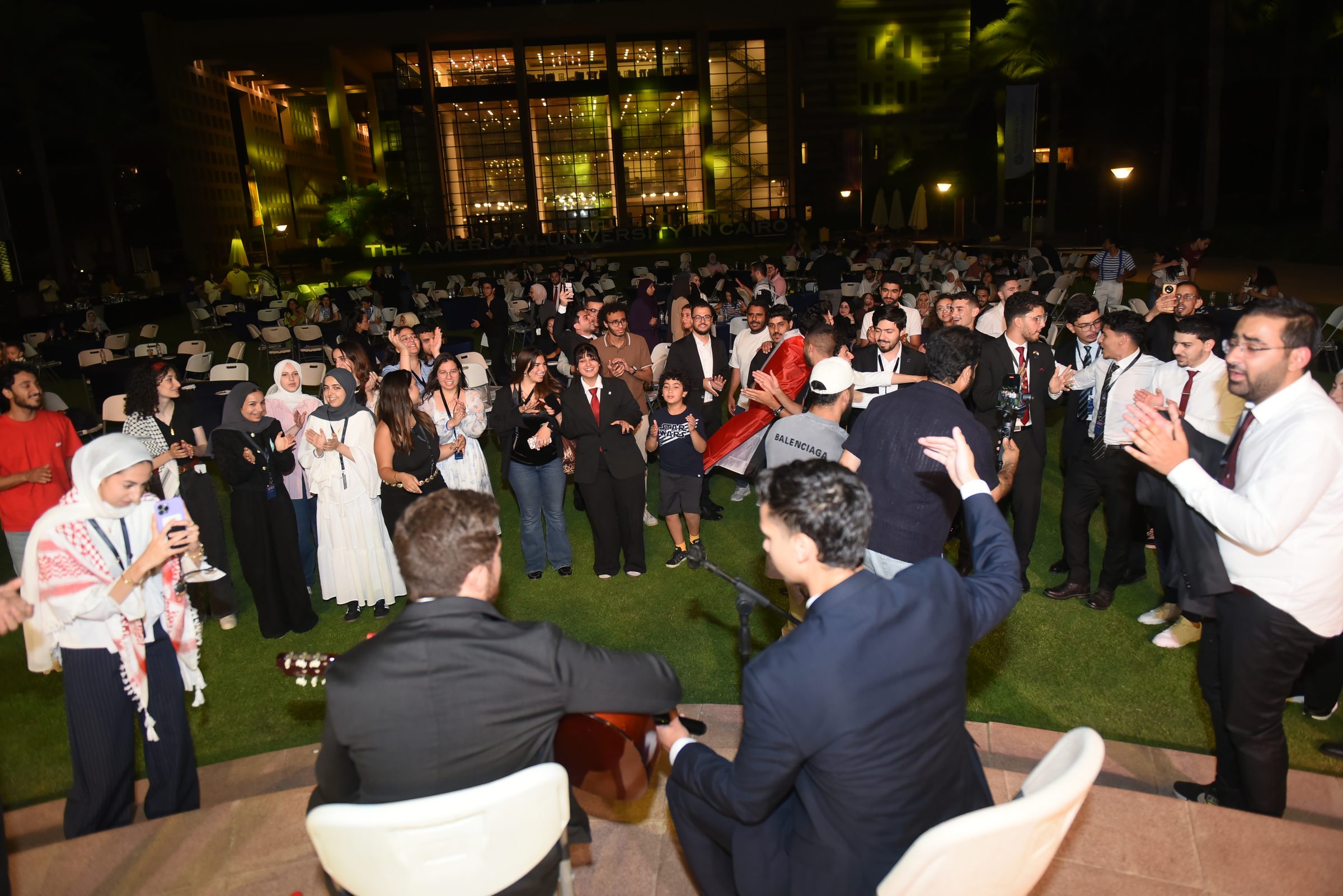 Delegates celebrating together on the campus lawn in the evening