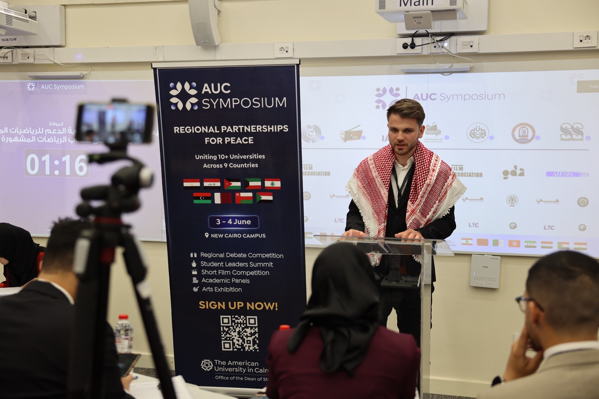 A debater speaking at the podium during the group stage rounds of the debate competition