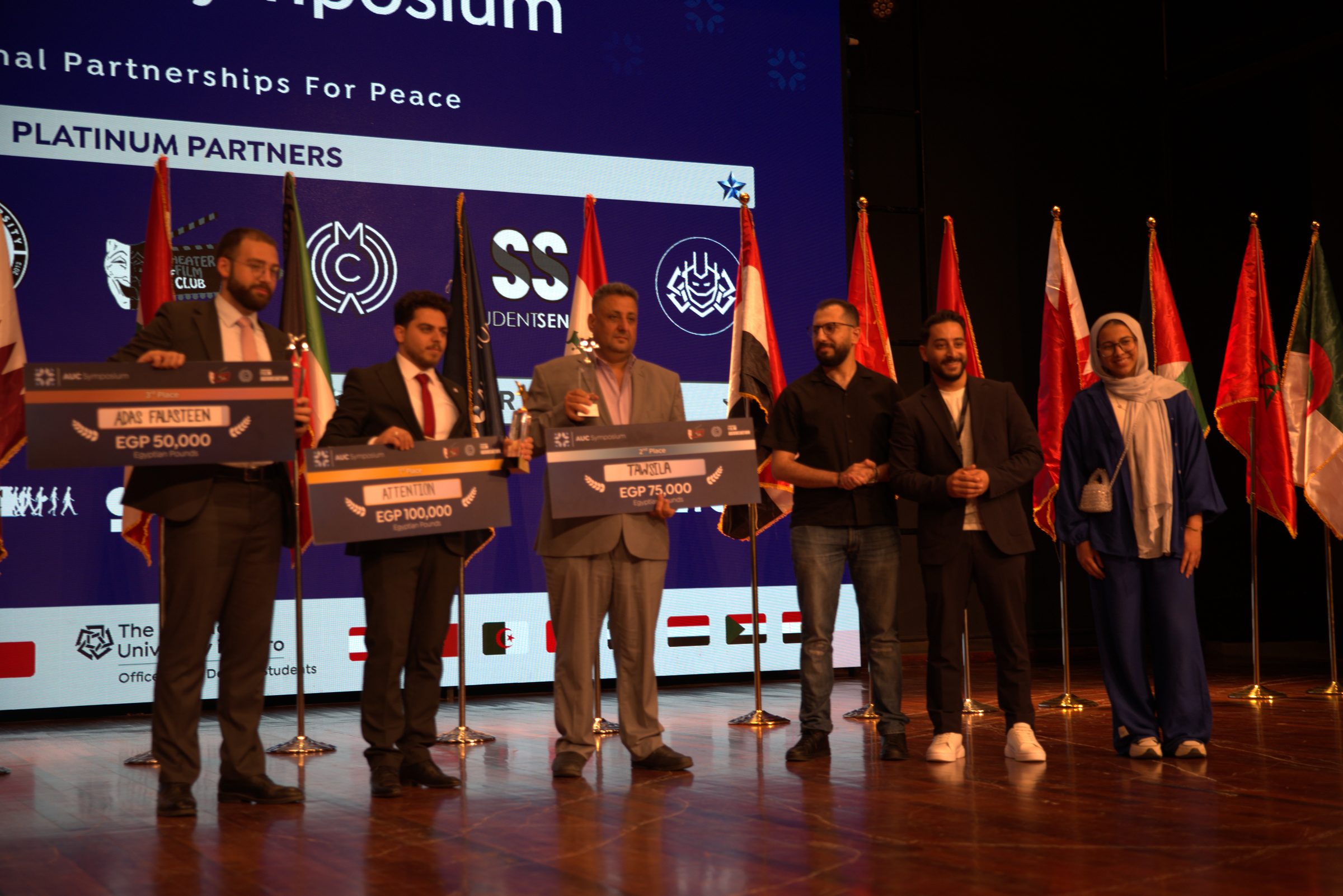The winning filmmakers on stage holding their prize cheques