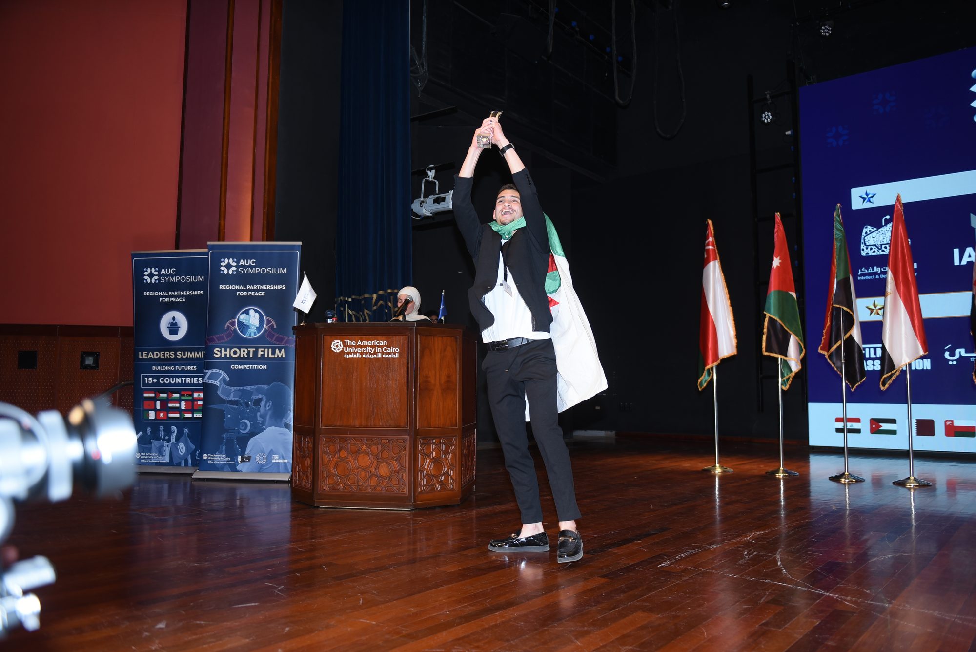 A delegate raising the trophy on stage